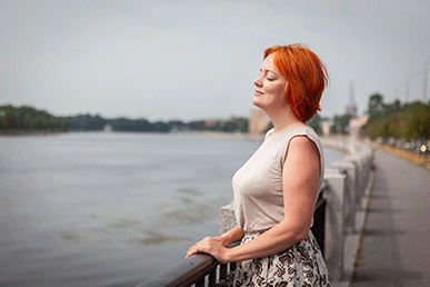 Profile shot of a woman living with HIV soaking in the fresh air at a nearby body of water